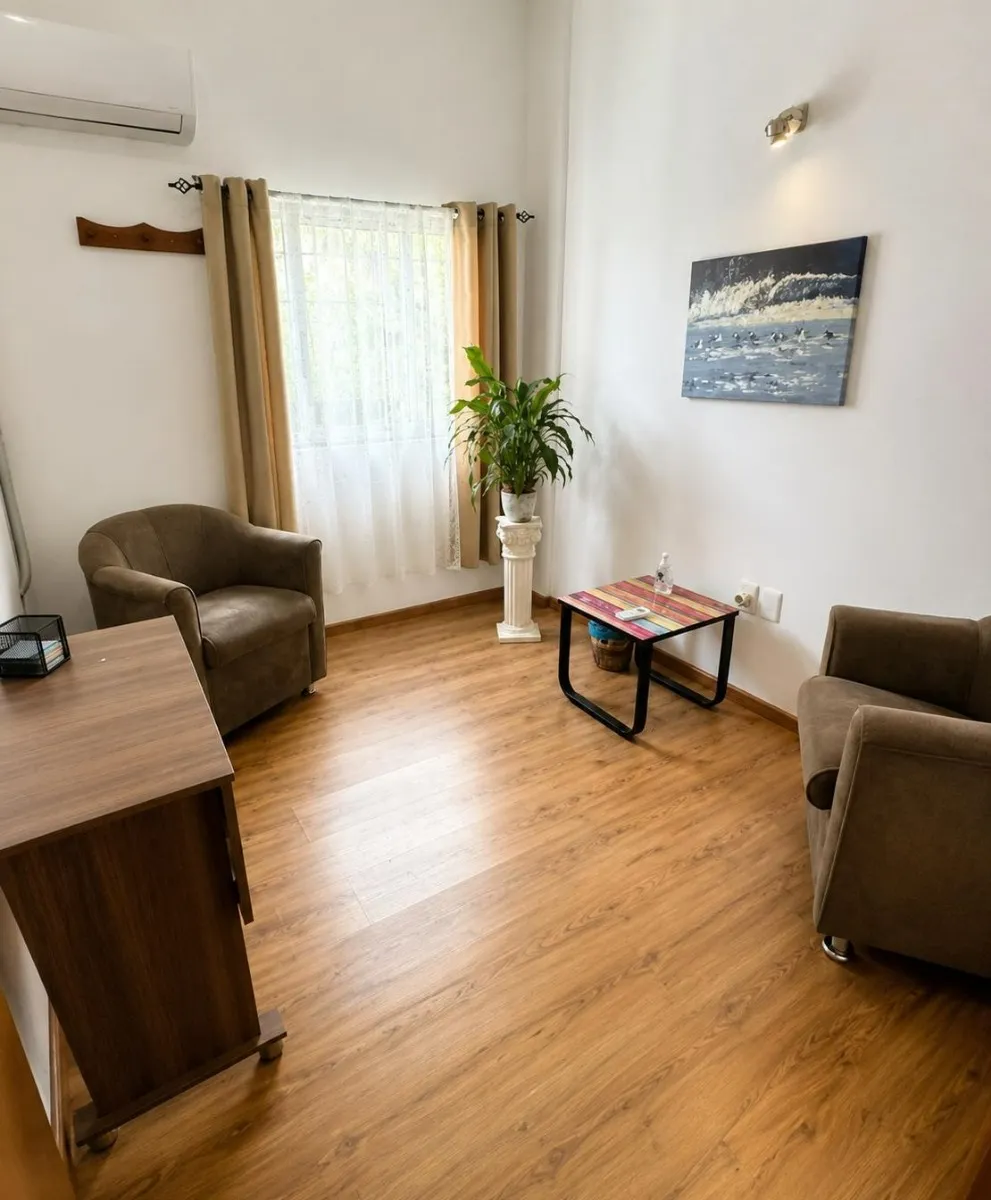 Consultorio 3 con sillones marrones y escritorio